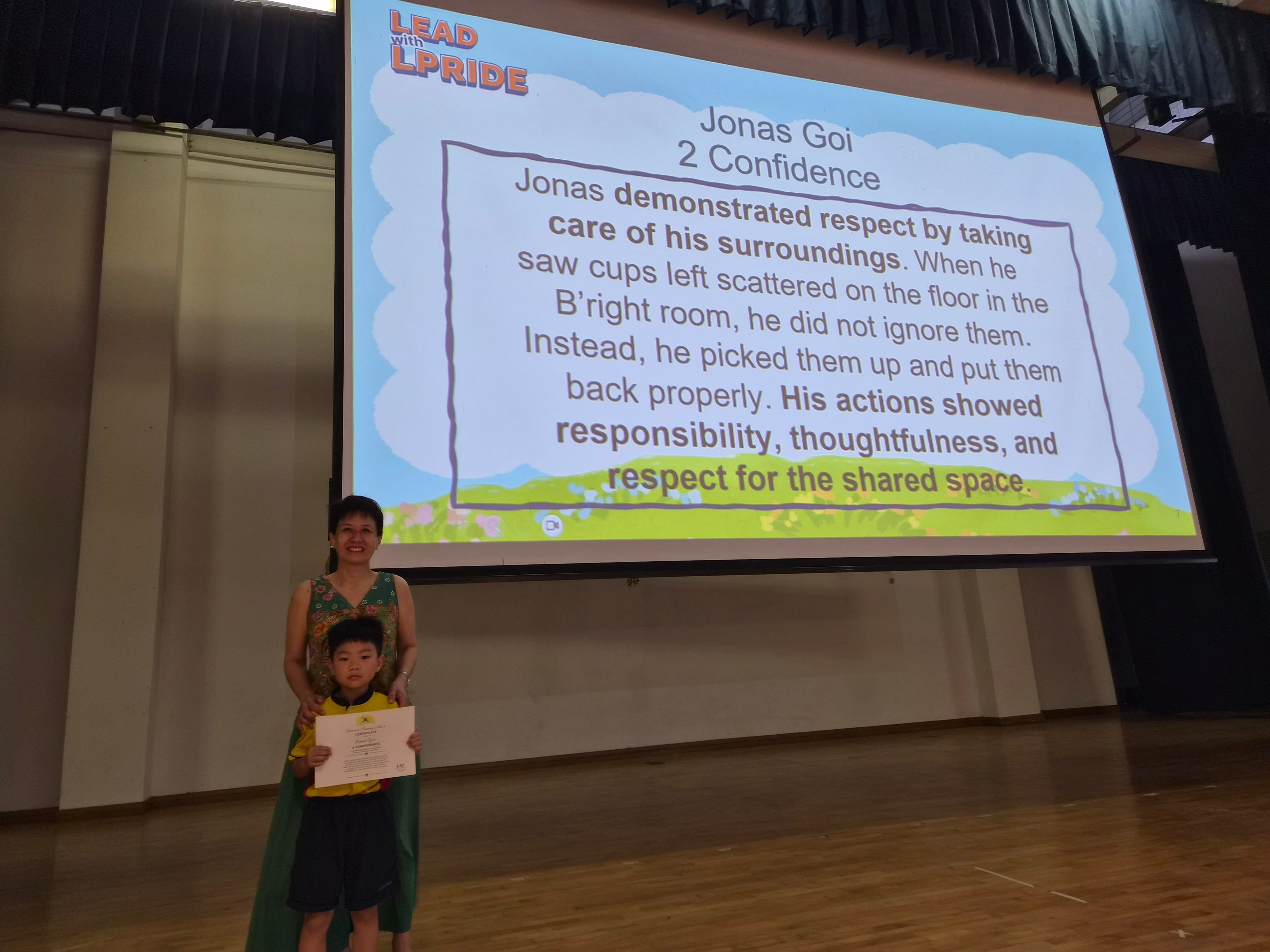 Jonas Goi receiving his certificate from Mrs Liang on stage